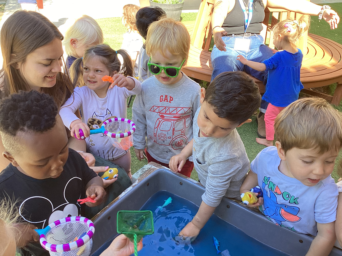 TA_Bailey-Theisen-interacts-with-toddlers-around-the-water-table